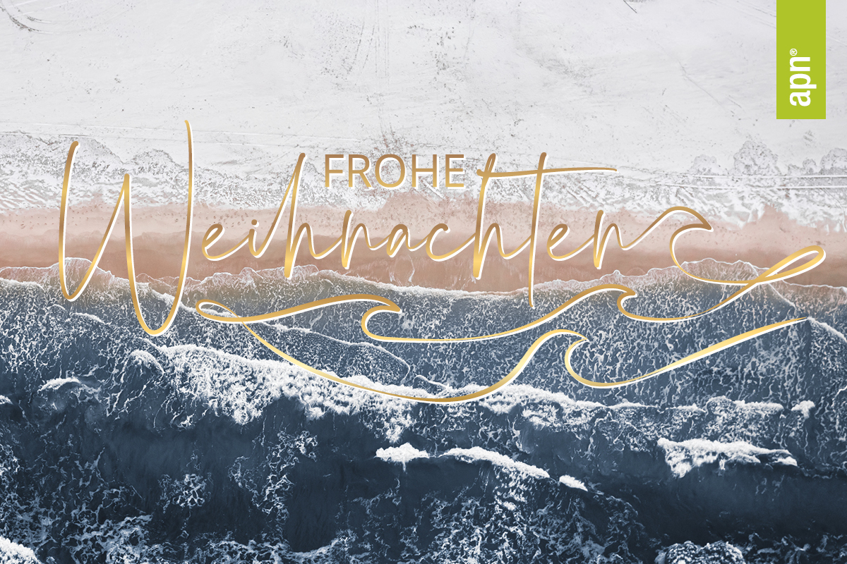 Frohe Festtage. Verschneiter Strand mit Wellen aus der Vogelperspektive. In der Mitte ist ein sehr zentraler Schriftzug in Gold: frohe Weihnachten. In der rechten oberen Ecke ein grünes Logo mit apn.